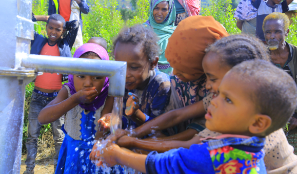 Children drinking from a communal water pump